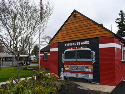 The outside of the Firehouse Axes building on Main Street. In the background, a C-TRAN bus passes by.